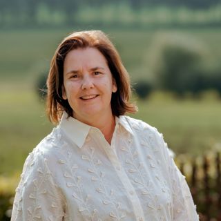 Portretfoto van Nicole met op de achtergrond een groen landschap