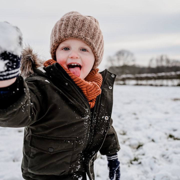 Winterparadijs Zuid-Limburg, jongetje die in de sneeuw speelt met sneeuwballen