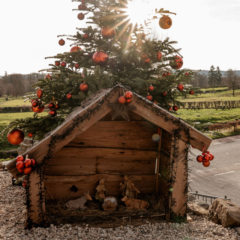 Twee dames lopen langs een kerststal in het heuvelland.
