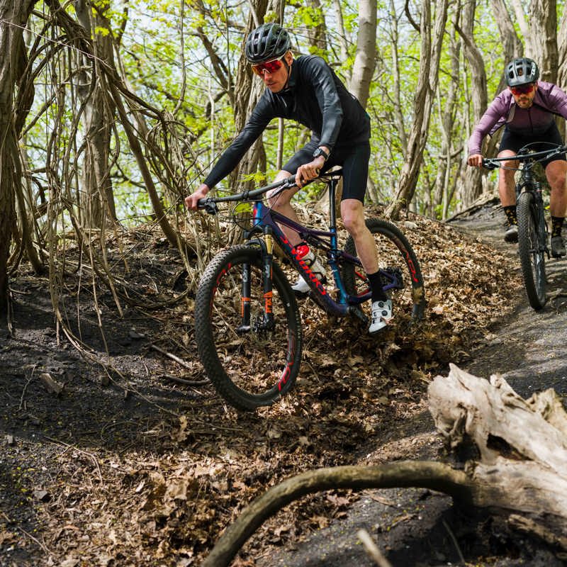Twee stoere mountainbikers komen offroad een bospad naar beneden.