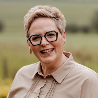 Portretfoto van Vera met een groen landschap op de achtergrond